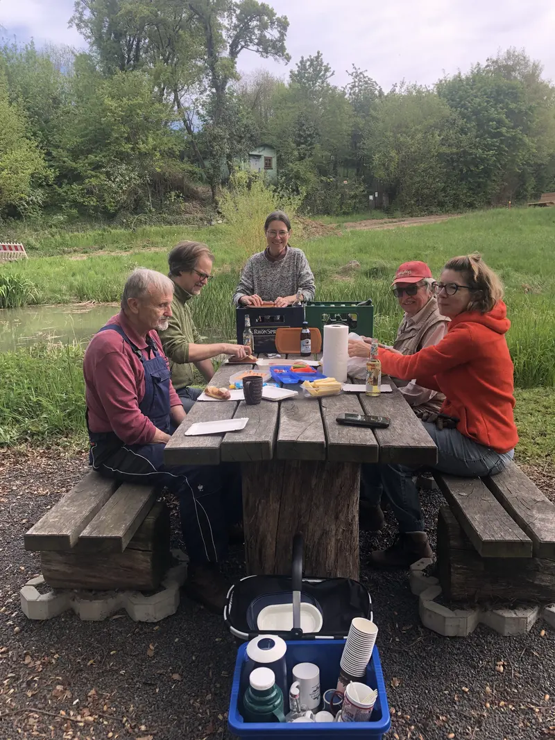 Menschen beim Picknicken am Dorfteich