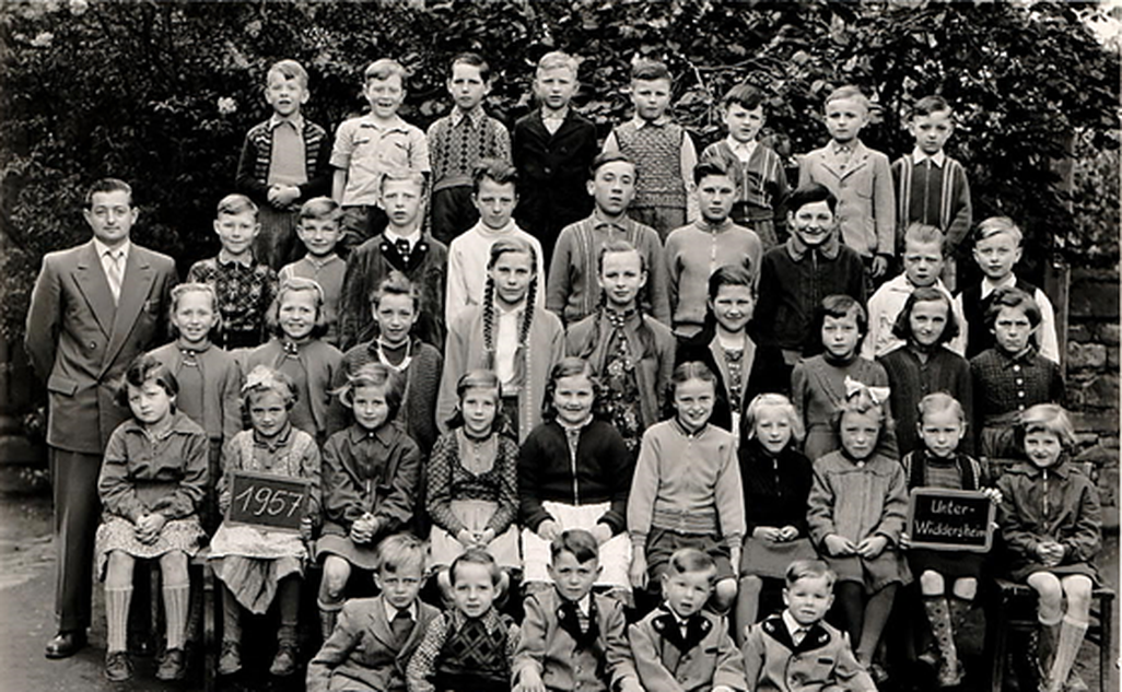 Volksschulklasse Jahrgänge 1 bis 8 im Jahr 1957 mit Lehrer Hans Knaus (im Bild links)